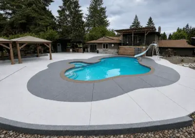 Pool deck with a light gray coating and a darker gray border around the pool
