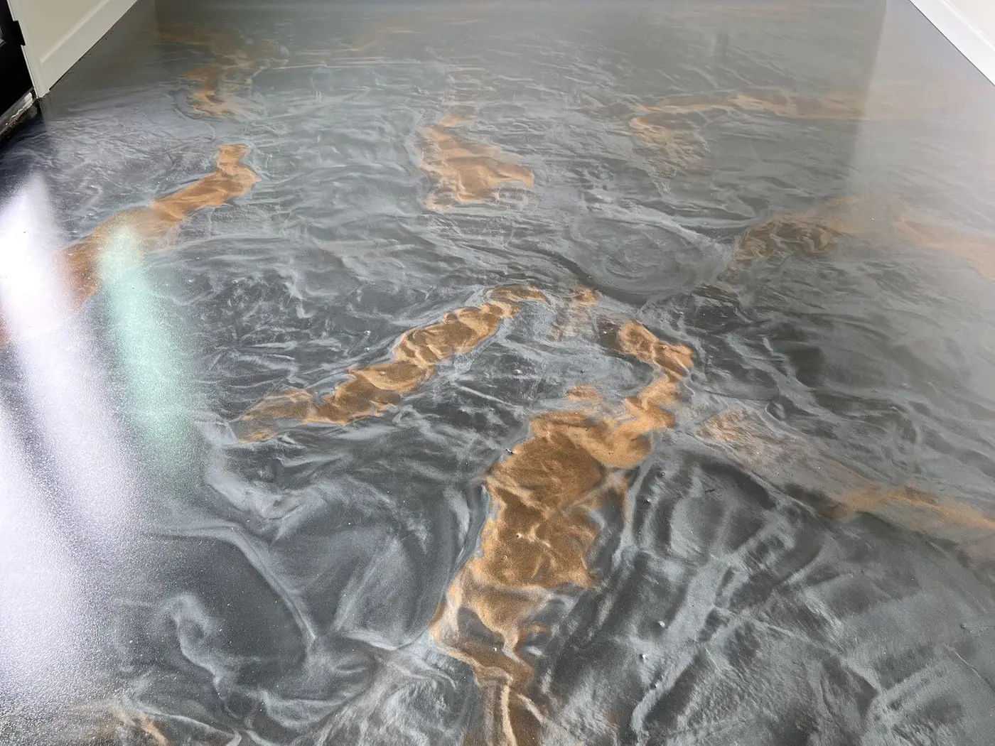 Close-up of a metallic epoxy floor with gray and copper swirls