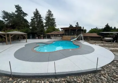 Pool deck with a light gray coating and a darker gray border around the pool