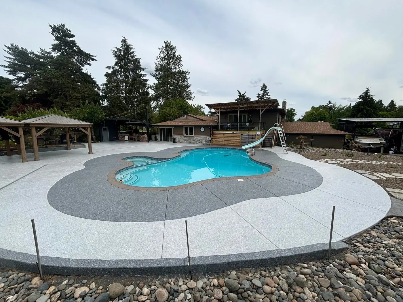 Pool deck with a light gray coating and a darker gray border around the pool